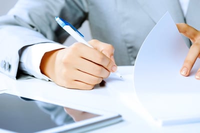 Image en gros plan des mains d’une femme d’affaires signant des documents